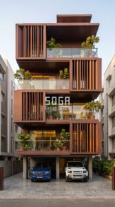 stacked interlocking box volumes with protruding metal fin screen elements in matte powder-coated RAL 8016 mahogany brown steel cladding, Kolkata - parametric metal facade by SOGA Design Studio