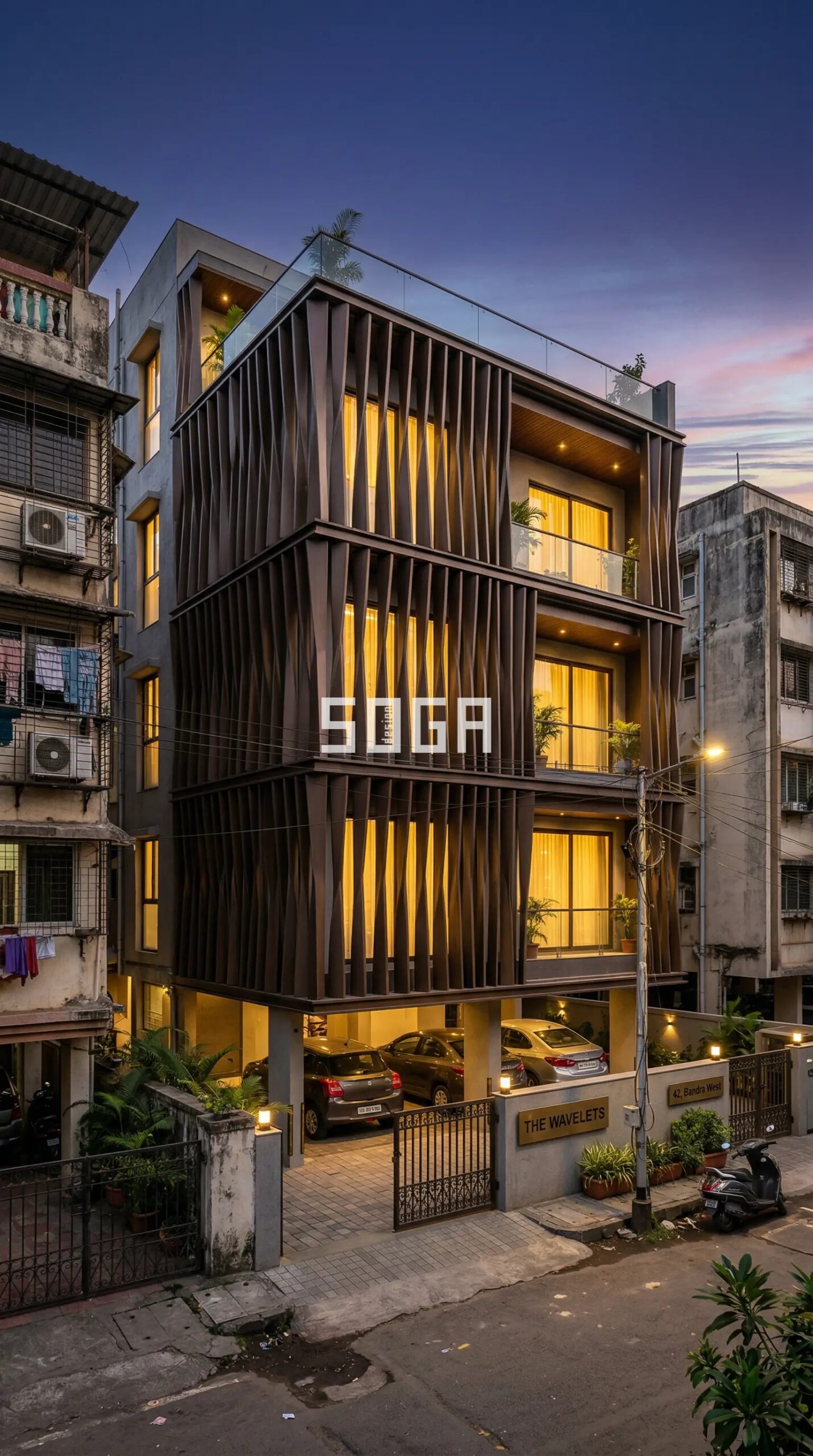 Parametric twisted aluminium fin cladding dark bronze on G+3 Indian residential building Mumbai at dusk
