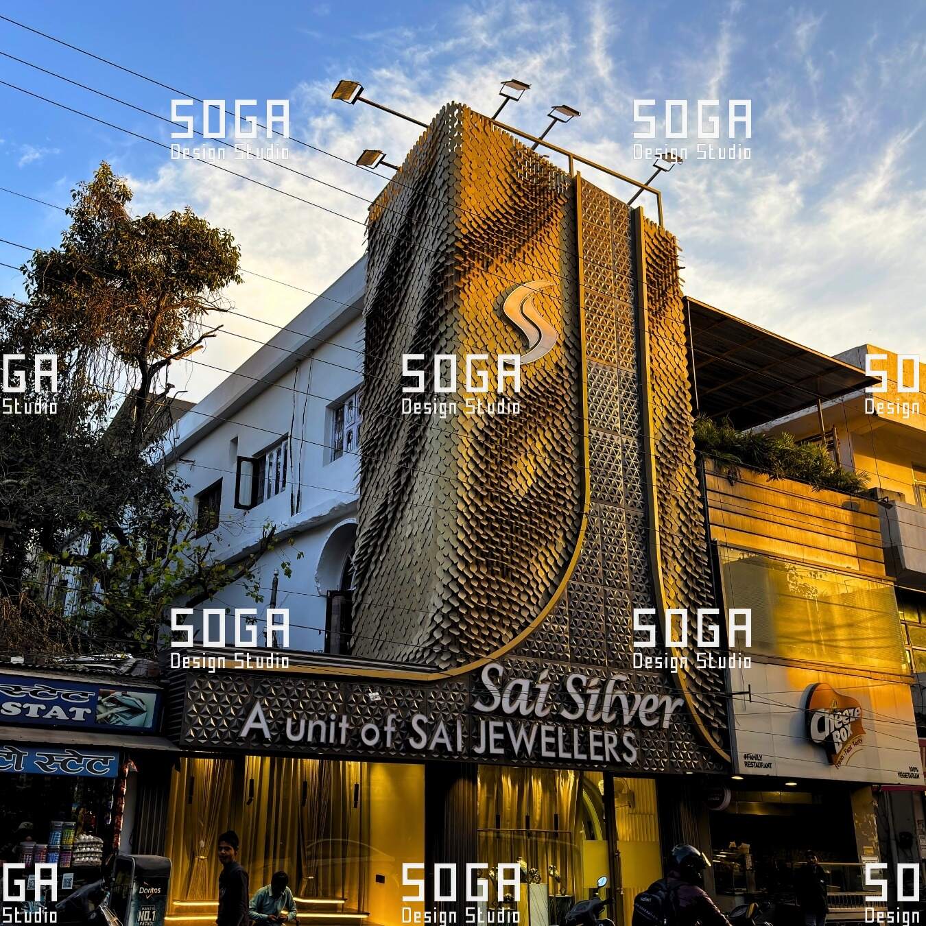 Sequin facade of overlapping metal scales sweeping across a retail building elevation in India