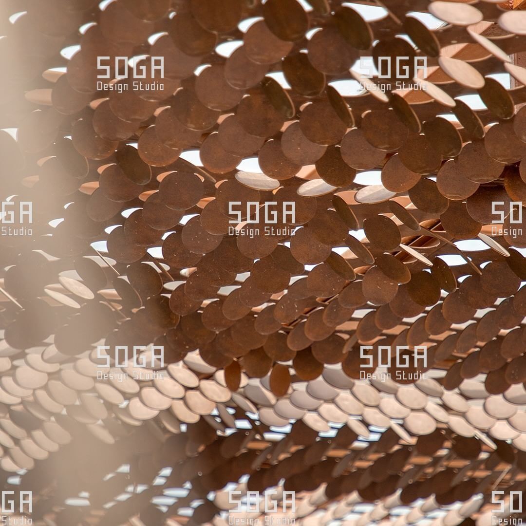 Close-up of formed coin facade discs catching light across their dished profile