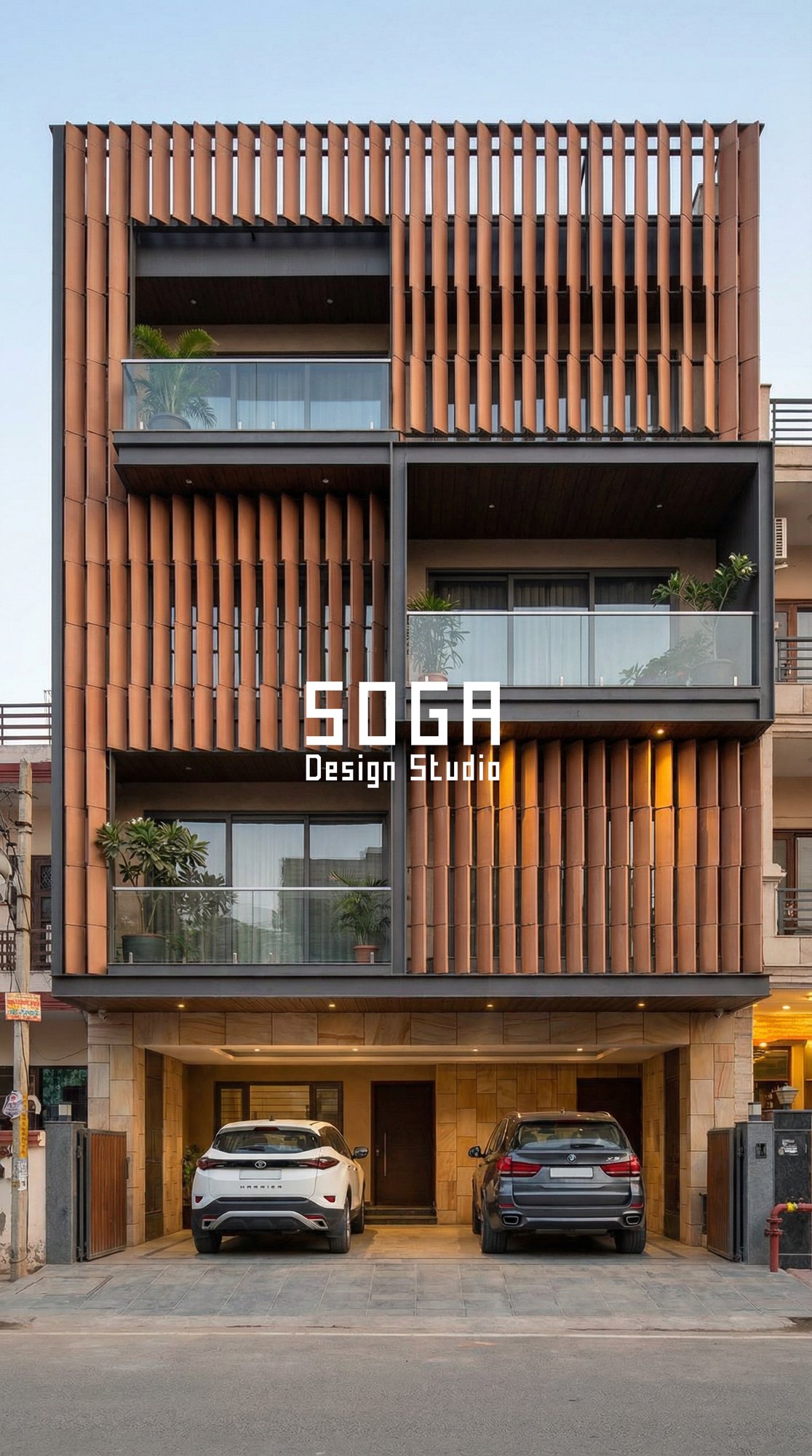 Terracotta vertical louver grid front elevation with sandstone base and stilt parking, India — SOGA Design Studio