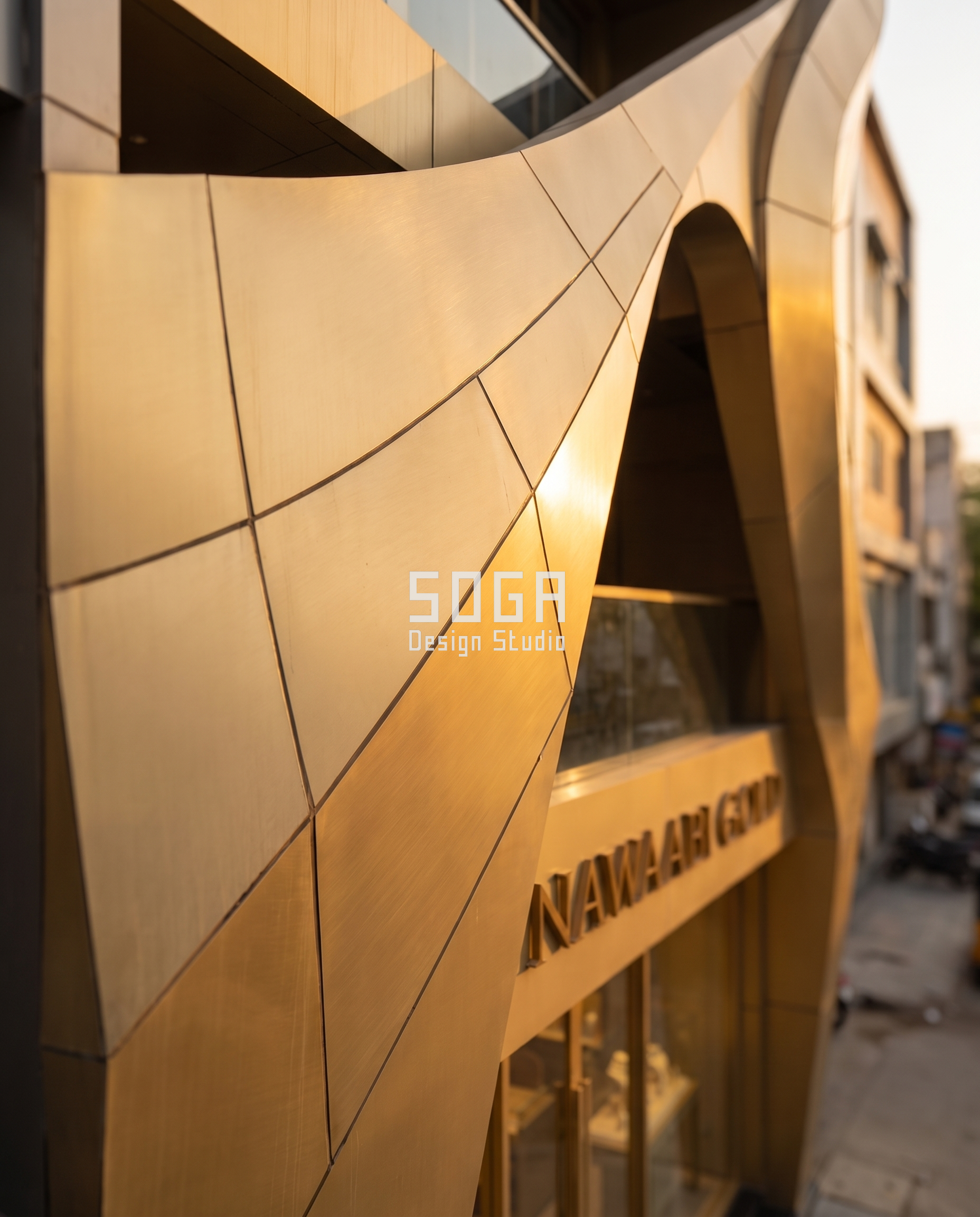 Nawaabi Gold: A Jewellery Showroom Facade Folded and Curved Like Hand-Worked Gold 6 Close-up of the folded metal panel seams on the Nawaabi Gold facade catching golden hour light - SOGA Design Studio