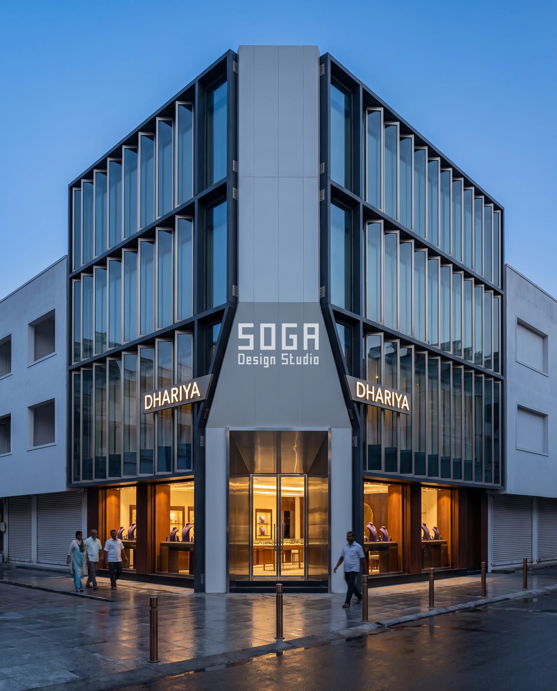 Chamfered corner jewellery showroom facade in Vijayawada, the 45-degree cut face carrying the entrance between two pleated low-iron glass street elevations at dusk