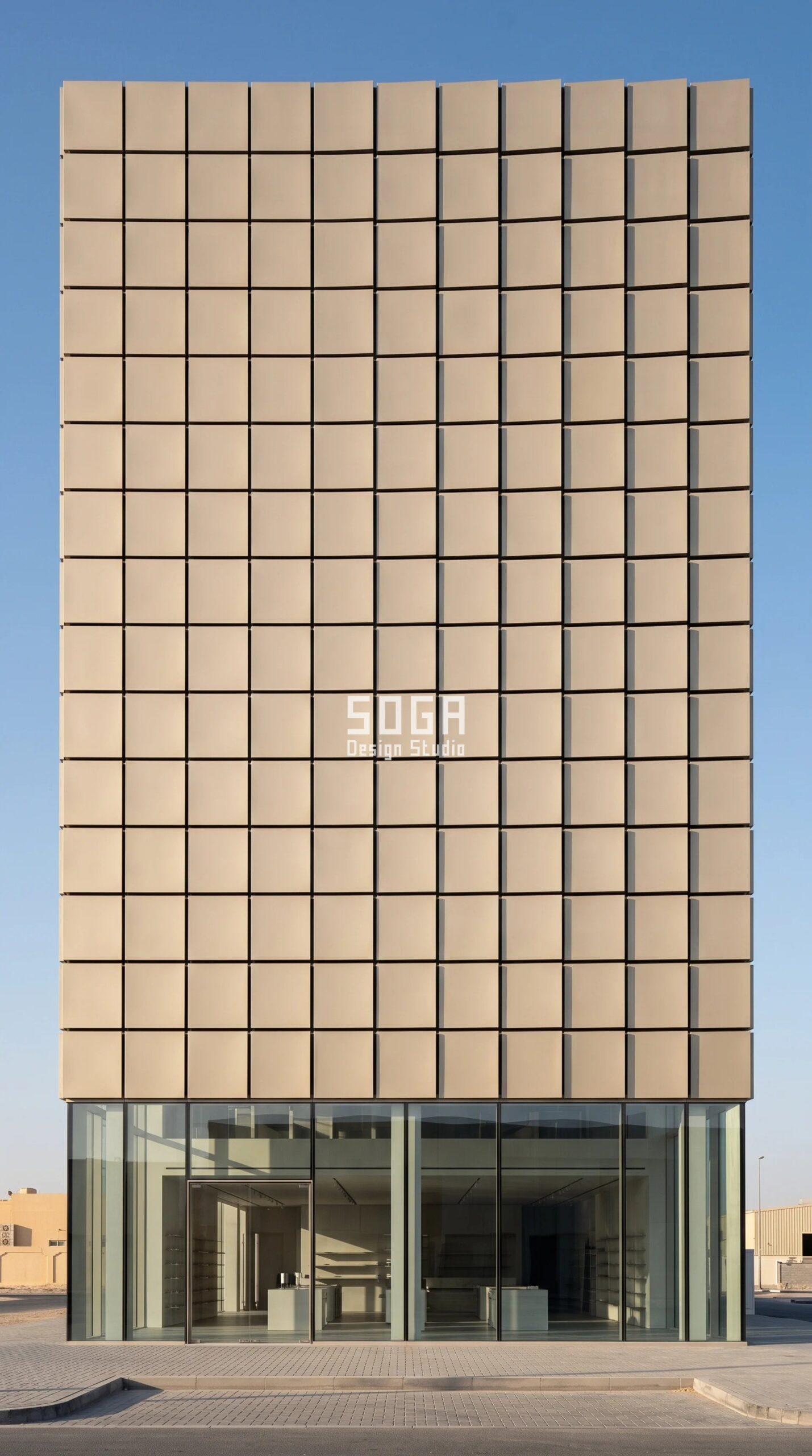 Parametric Camber Plate Course commercial facade in Dubai - sand-pearl coil-coated metal plates above a full-height vitrine on a G+5 flagship showroom, press camber rise stepping 8 to 40 mm across the frontage - SOGA Design Studio