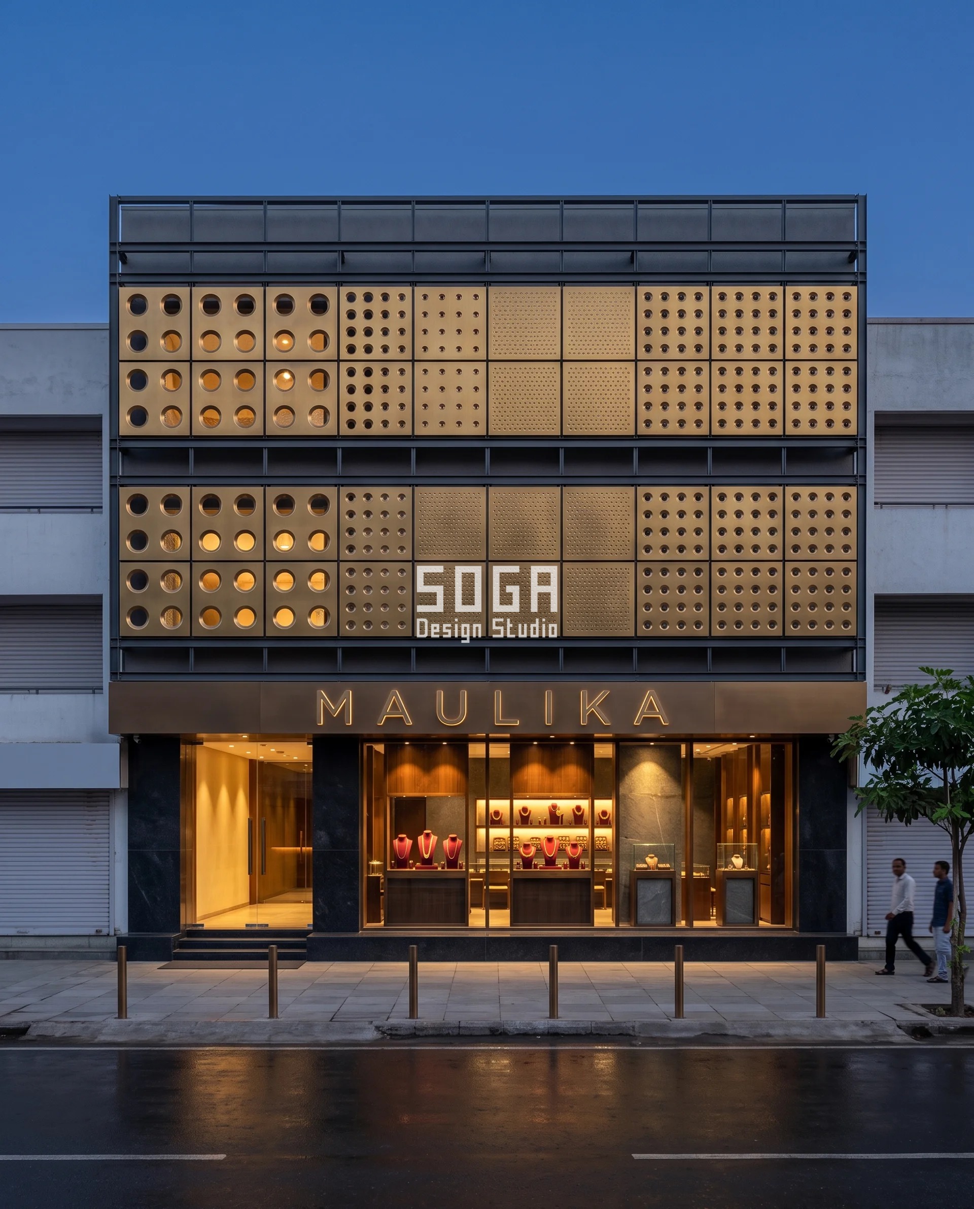 Graduated Perforation Jewellery Showroom Facade India 1 Whole 21 metre elevation of a graduated perforation jewellery showroom facade in Surat at blue hour: 24 dished-collar bronze cassettes in a steel carrier frame, open enough to see through above the entrance and tightening to an almost solid dimpled field over the central display wall