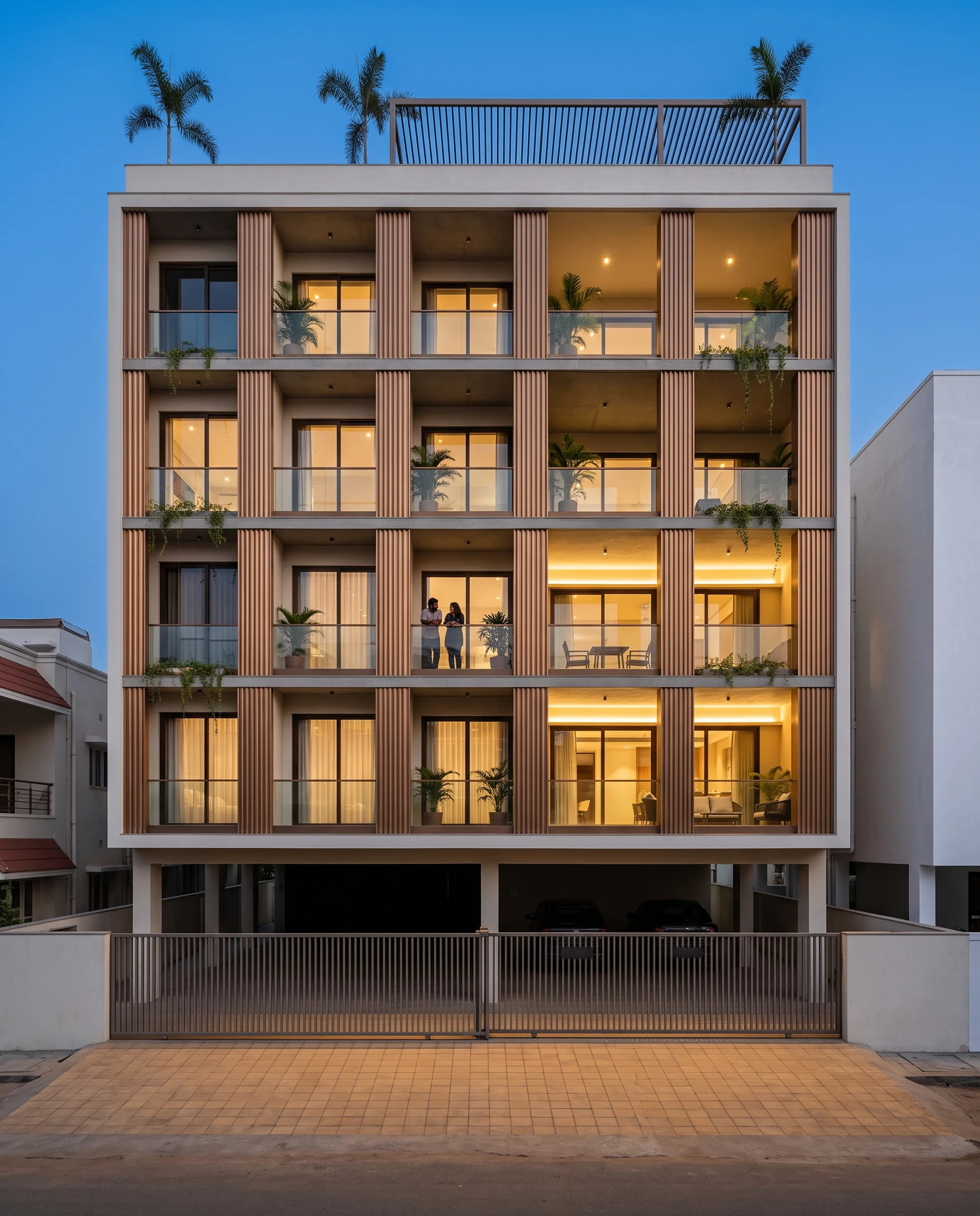 Facade Screen Without Making the Room Dark: India Numbers 4 Ginger-bronze fluted piers on a six-storey Nellore residence at dusk, each standing further off the glass so the cove-lit loggia behind it deepens left to right - an Indian facade screen without making the room dark.