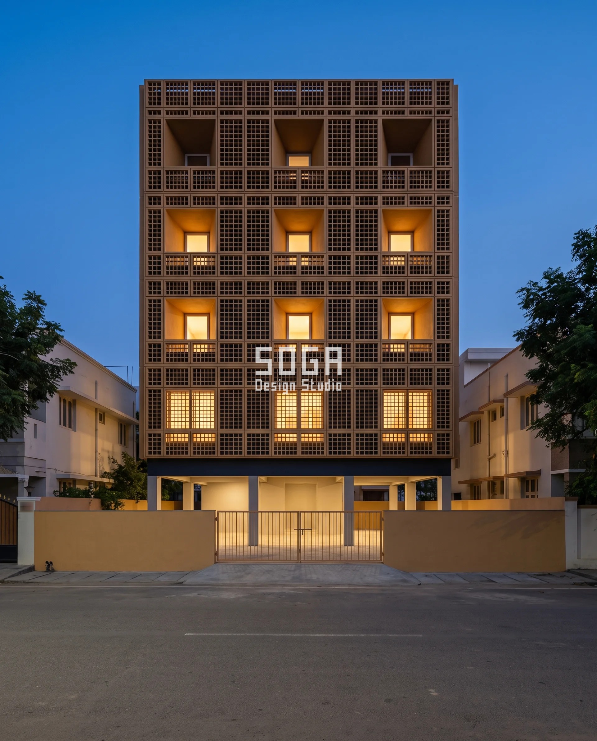 Blue-hour Tirunelveli house behind a deep cast aluminium grille, warm interior light sitting at four different depths inside identical square cells - cavity depth is the quietest way to reduce sun glare at a living room window in India