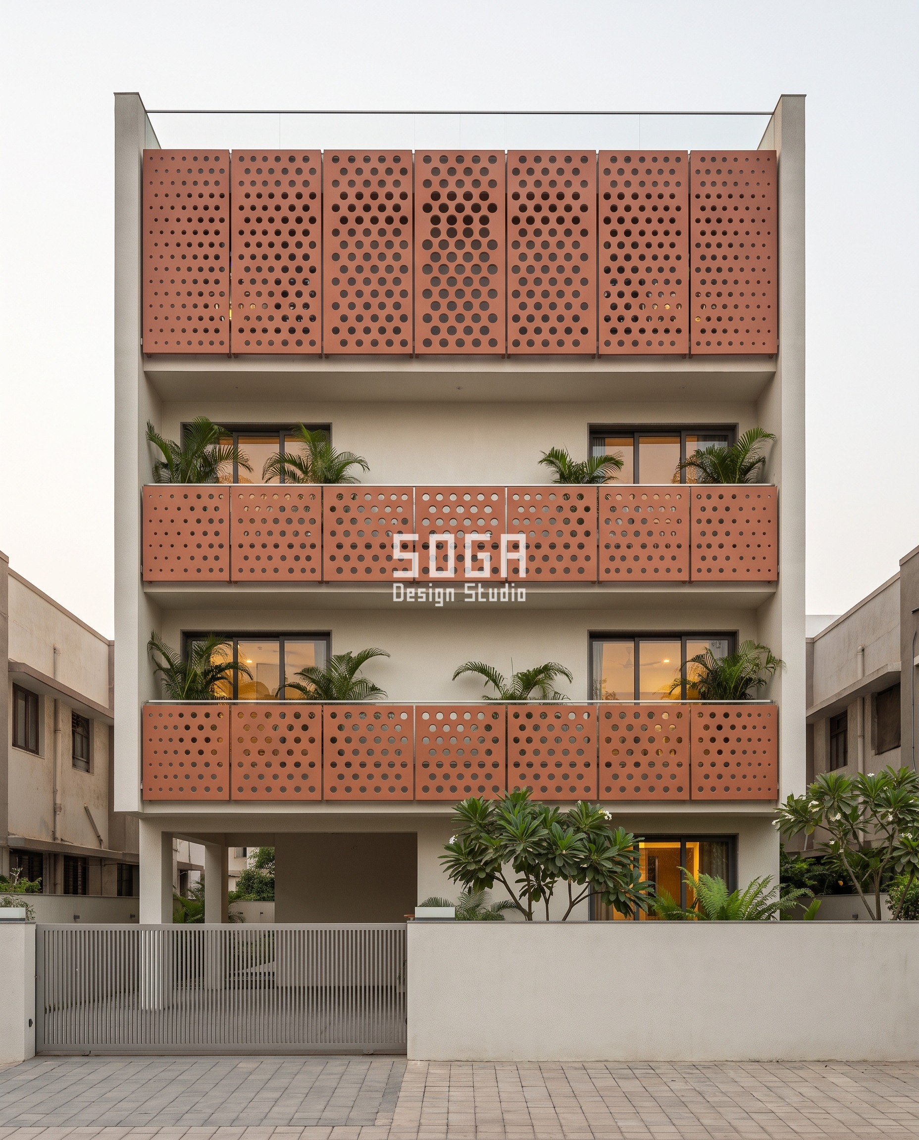 Parametric Iris Plate villa facade in Bodakdev, Ahmedabad - punched 8 mm alloy balcony-band screens in clay terracotta powder coat, hole diameter opening from 60 mm at the lower piers to 340 mm at the centre of the top band