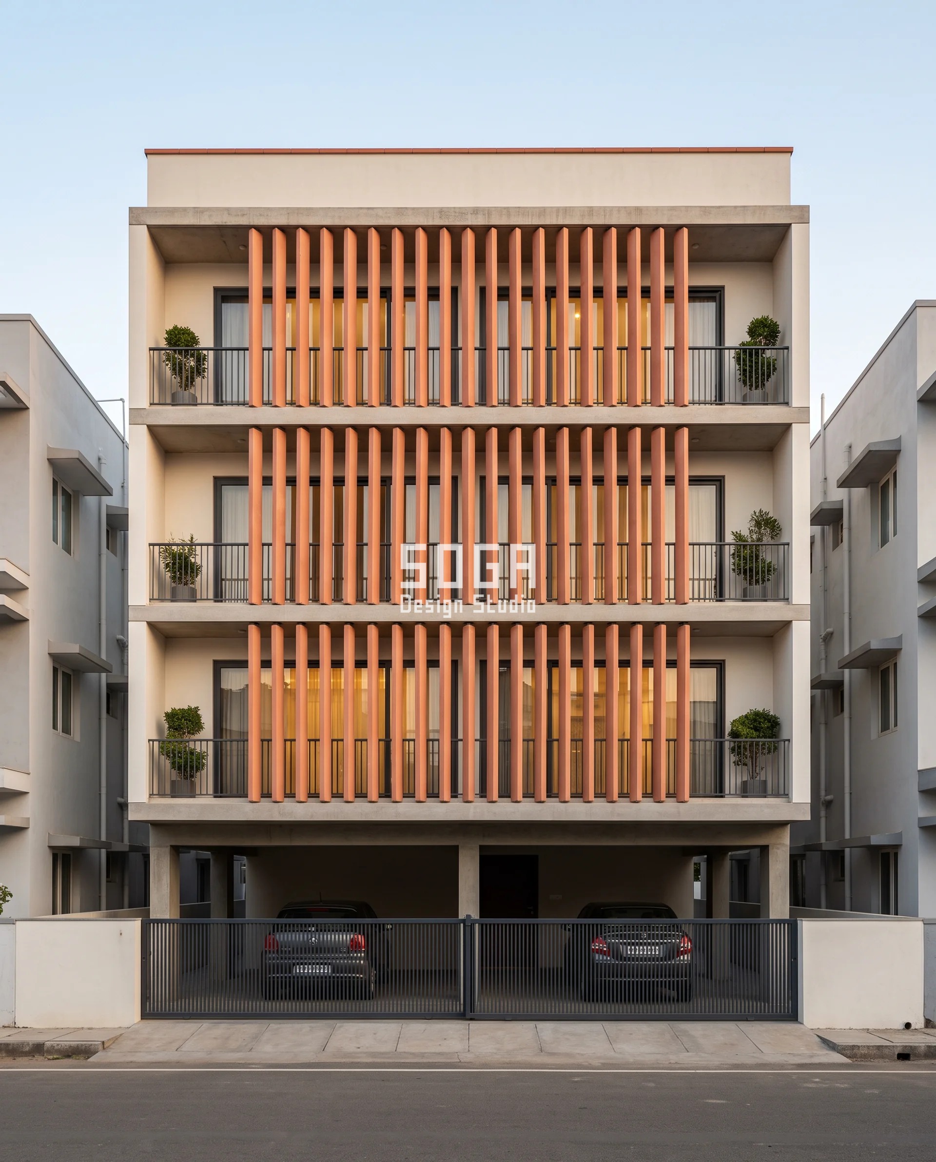 Reduce Road Noise House Facade India: Depth, Not Gaps 4 Blush-terracotta baguettes standing dead plumb at 240 mm centres across three balcony bands of a Tiruppur house, each blade turned to its own fixed angle while the 195 mm gaps between them stay wide open - set angle rather than closer spacing used to reduce road noise on a house facade in India.