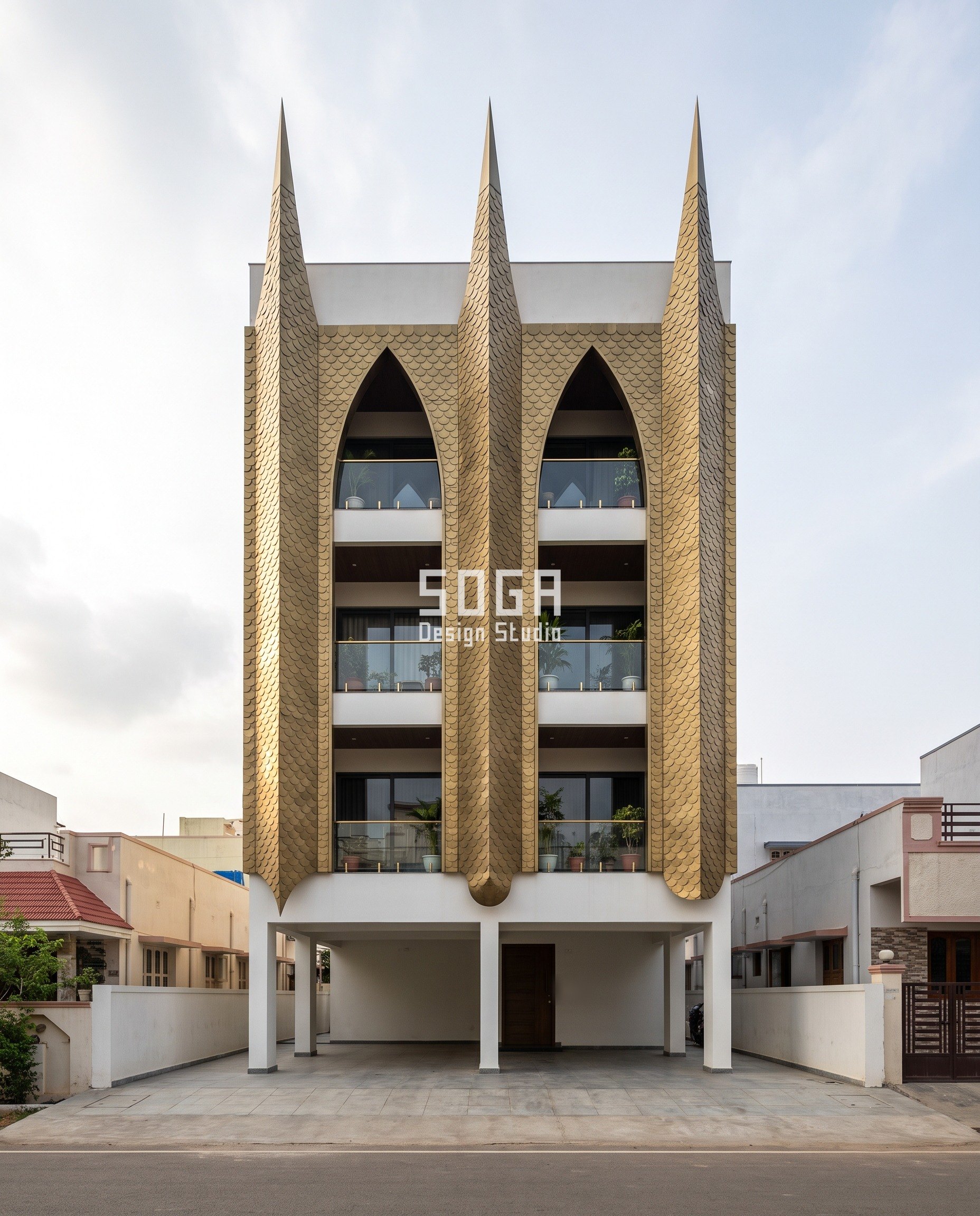 Extendable house elevation in Kakinada: three fat antique-brass stainless lobes on a G+3 house, the pressed scales stretching from a 300 mm round to a 300 by 900 mm teardrop across the frontage.
