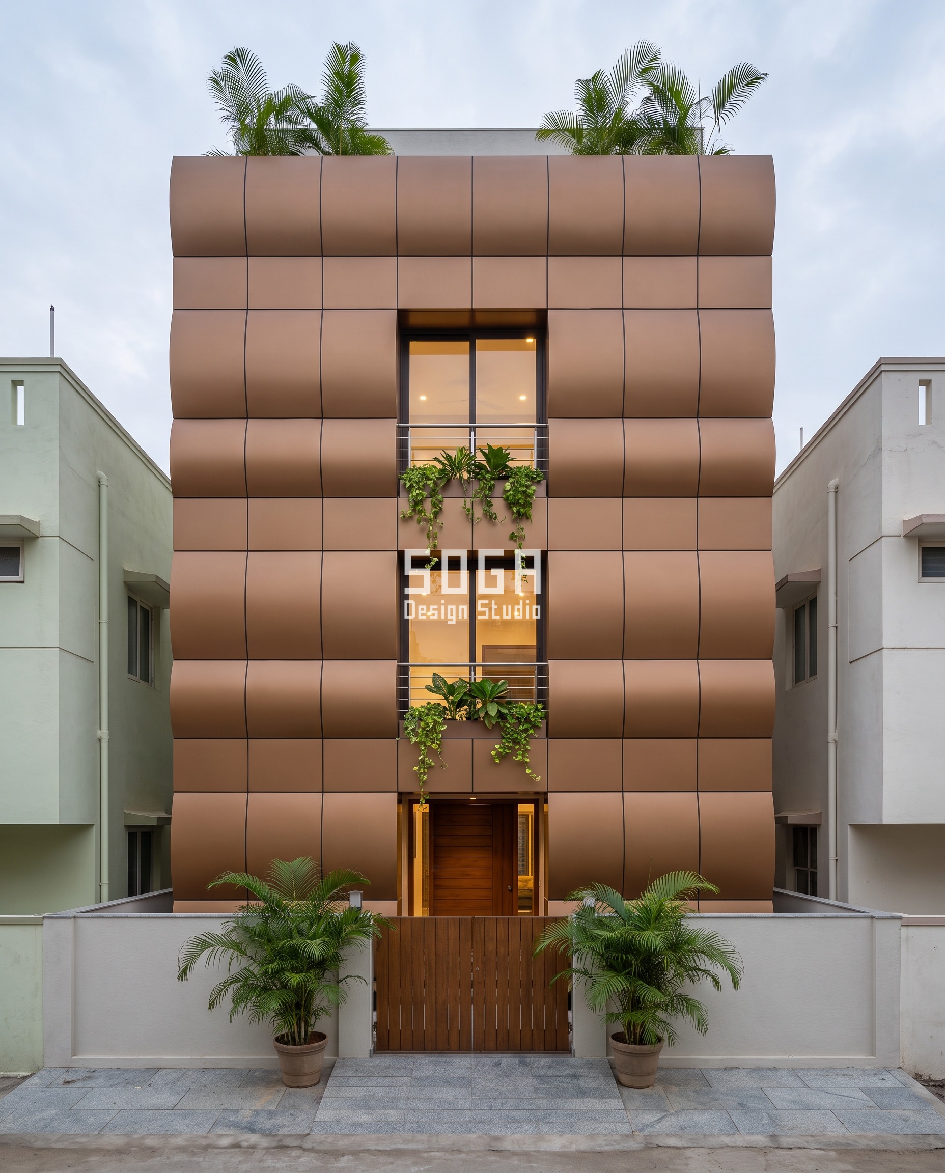 East Facing House Elevation Design India: The 3-Hour Rule 4 East face elevation design in Vellore: a narrow G+3 house wrapped in cognac-bronze anodised cassettes rolled into convex arcs with straight level joints, around a stacked column of glass openings and trailing money plant