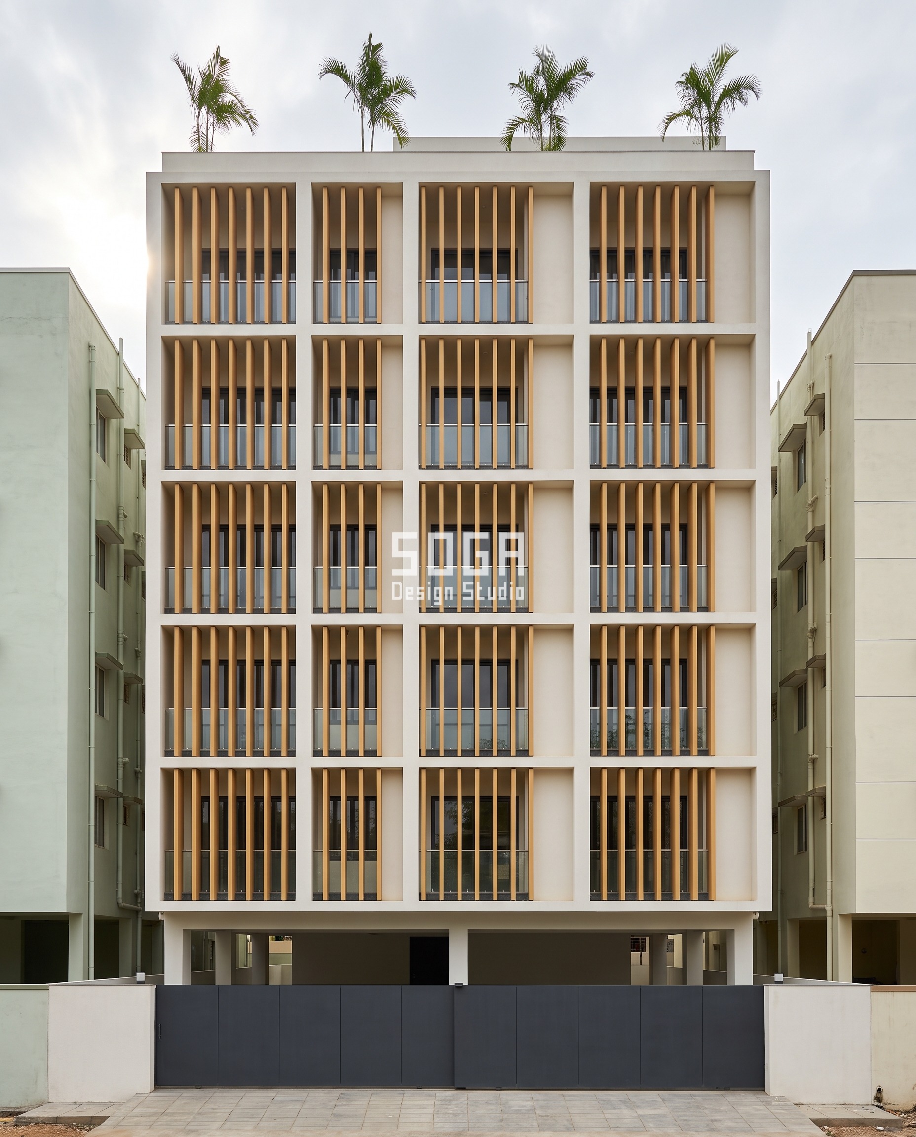 Uneven Windows House Elevation India: Choose The Angle 4 Chittoor G+5 house elevation design, India - identical sand-amber GFRP blades with the bare plaster strip beside each pilaster drifting 0, 120, 240 and 360 mm, making uneven windows without changing a single window.