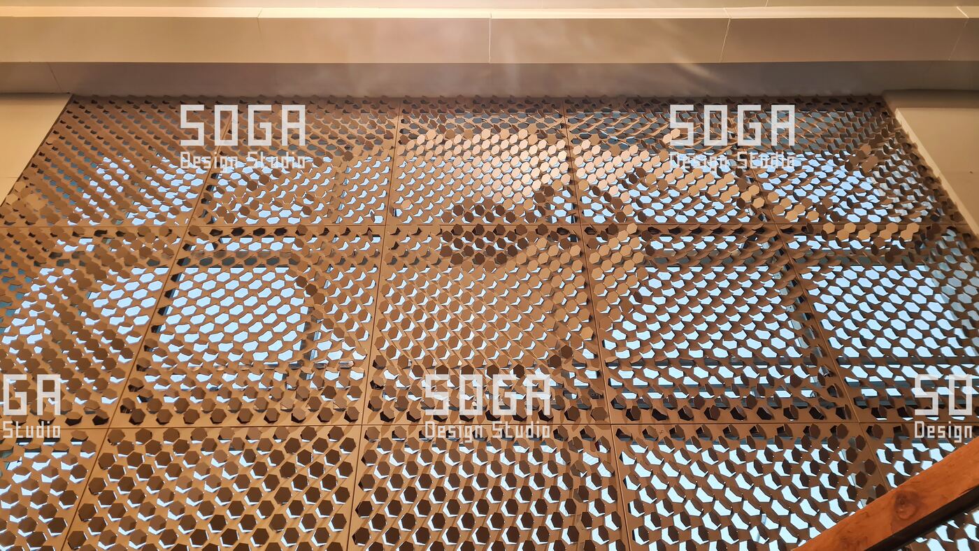 Metal Coin Cladding: Which Buildings It Suits, and Which It Does Not 6 Coin cladding used on a canopy soffit, lit from below so the disc field reads overhead