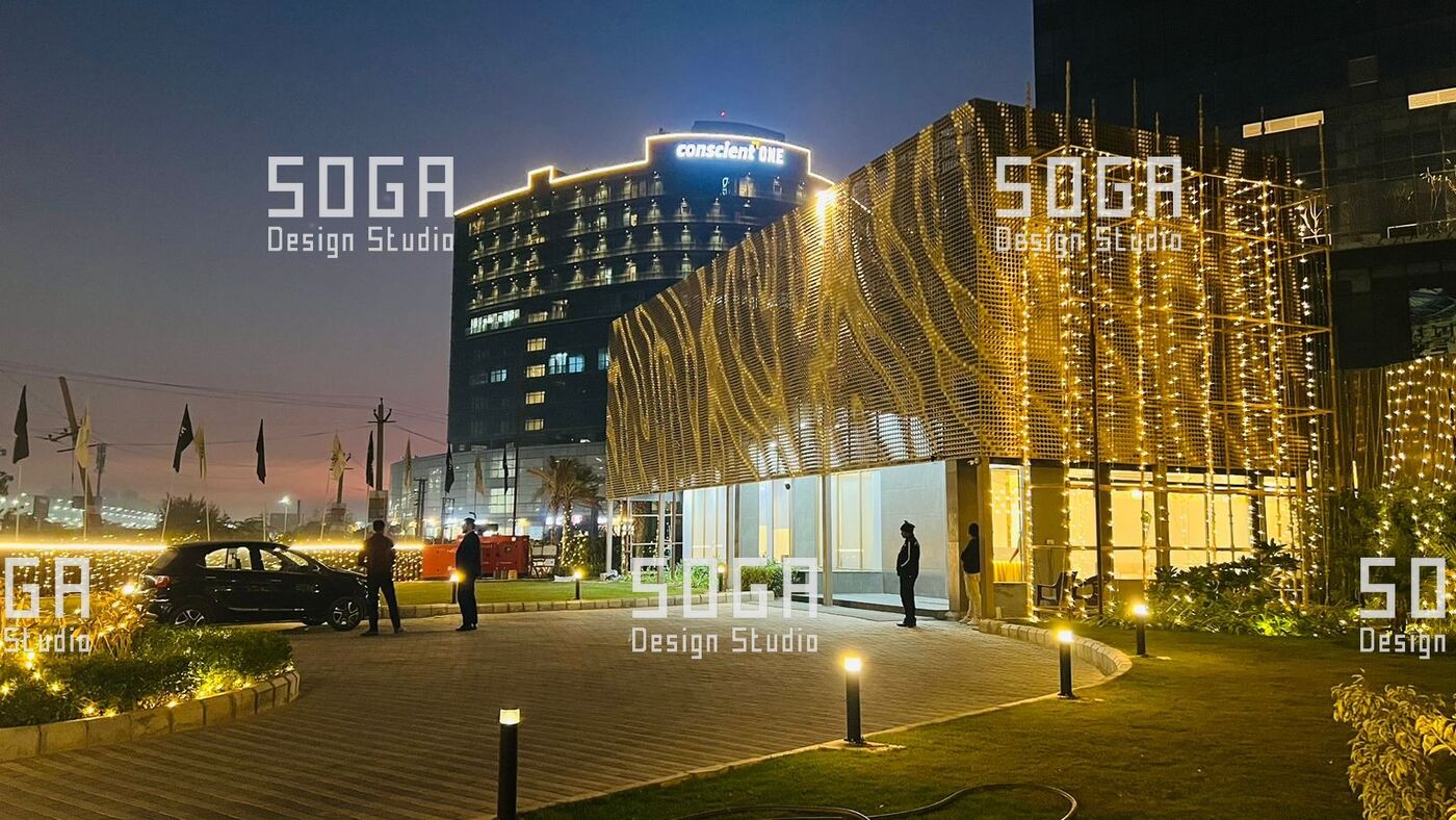 Metal Coin Cladding: Which Buildings It Suits, and Which It Does Not 8 Night view of a coin-clad building from the approach road, with the frontage lit along its length