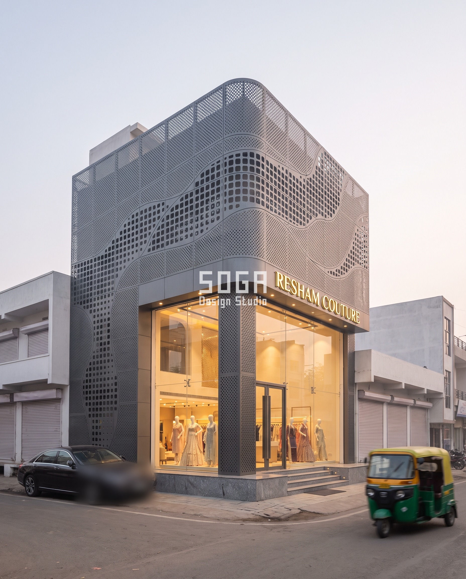 RESHAM COUTURE flagship showroom in Indore, a river-delta pierced graphite-grey steel skin wrapping the street corner above a glazed storefront, the parapet-height signage band naming the shop in lit metal letters